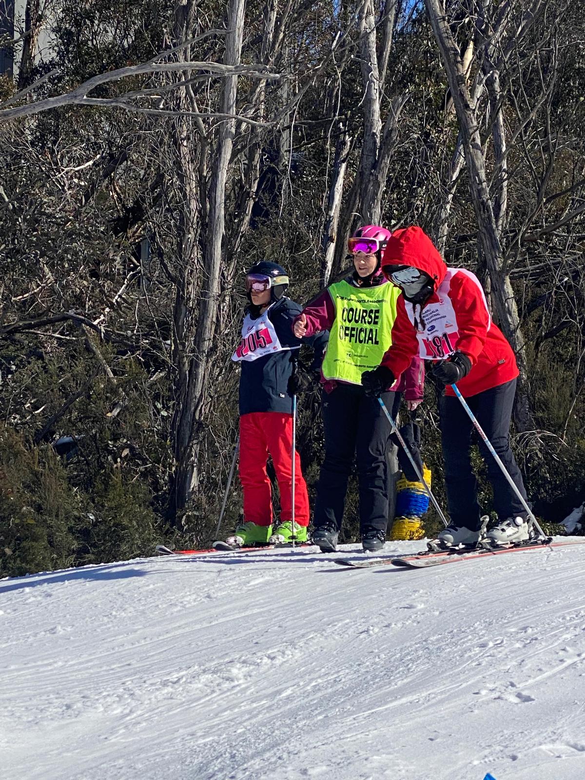 Young Interschools racer at the start gate with a course official at Thredbo