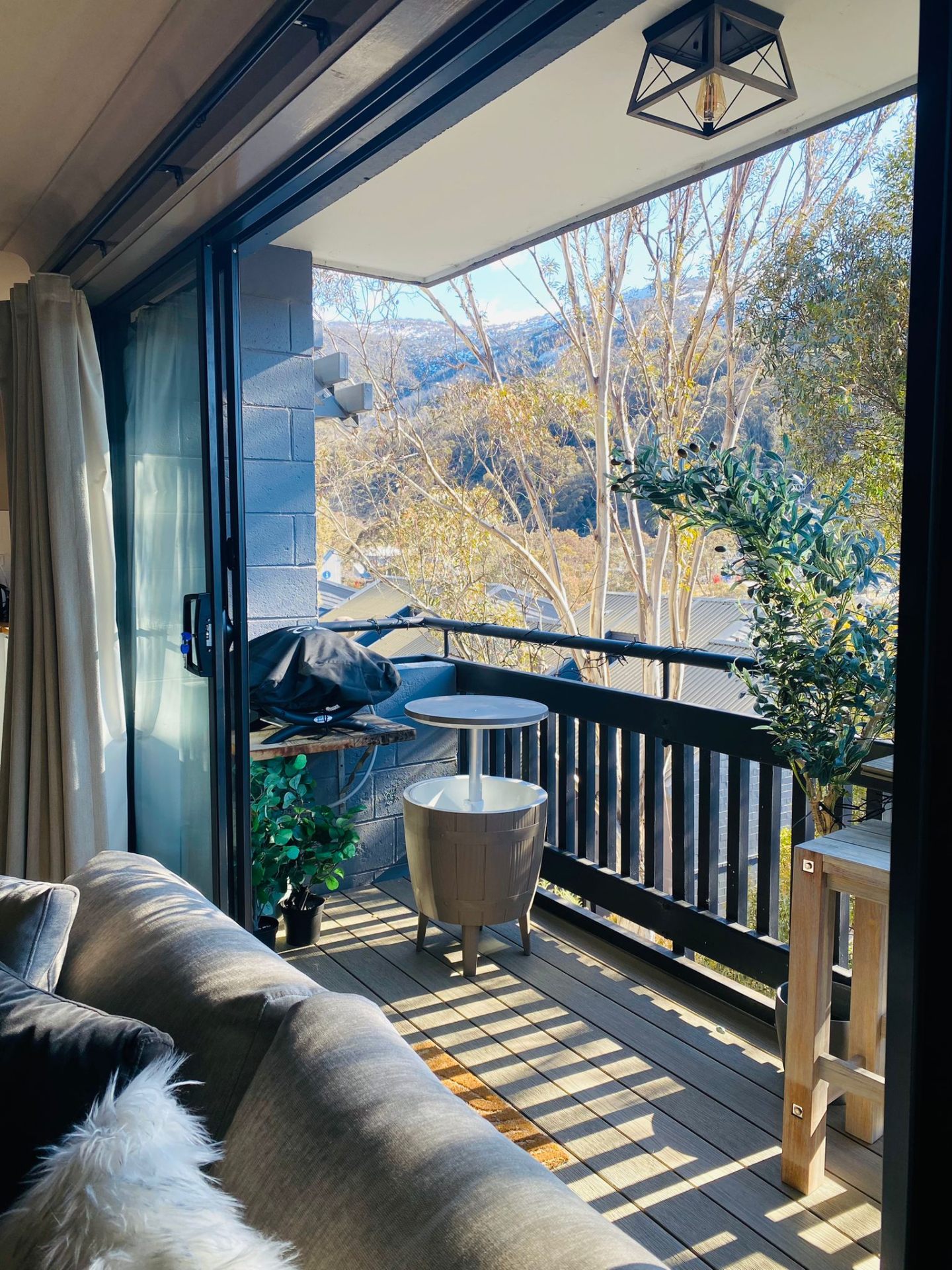 Sunny BBQ on the terrace at Chalet Charm Thredbo — outdoor dining with mountain backdrop on the private balcony