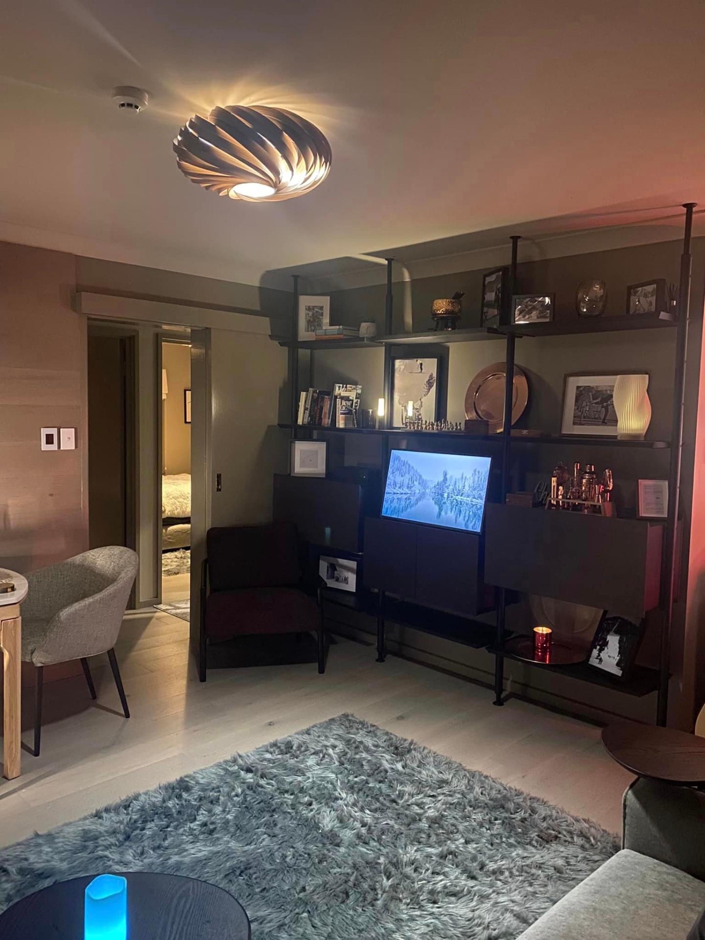 Chalet Charm Thredbo wooden entertainment unit — the centre point of the apartment, rich with copperware, a marble and brass chess set, retro framed pictures and Snow Polo and equine imagery inspired by St. Moritz